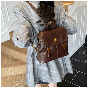 Detailed back view of vintage brown leather backpack with adjustable straps and metal lock