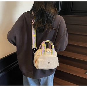Detail der beige Nylontasche mit buntem Jacquard-Gurt und floralem Muster für Damen