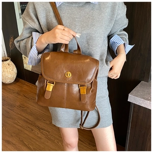 Detail of vintage brown leather backpack with golden metal buckle and flap closure