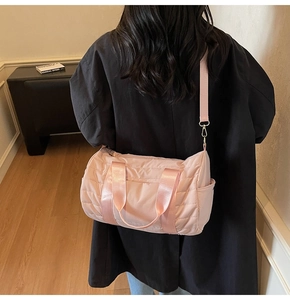 Detail view of pink quilted duffel bag with shoulder strap and stylish side pocket