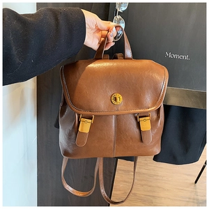 Detail showing the brown vintage PU leather backpack with a golden twist lock closure