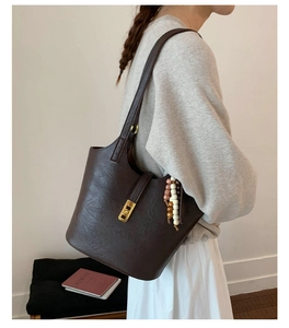 Detail of dark brown vintage bucket bag with bohemian colorful beads and gold clasp
