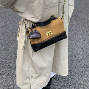 Detail of vintage patchwork crossbody bag with gold twist lock and chain strap