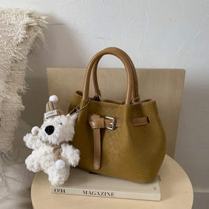 Textured woven mustard yellow bucket bag featuring a cute white plush puppy charm