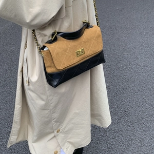 Detail of color-block flap bag featuring quilted suede and gold metal turn-lock closure