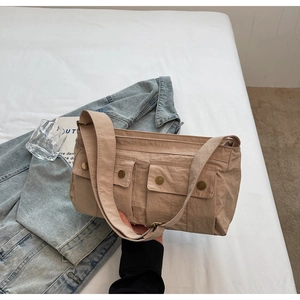 Detail of beige nylon shoulder bag with utility pockets and vintage bronze buckles