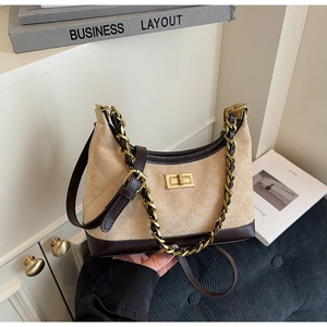 Detail of beige quilted suede bag with dark brown leather trim and golden twist lock