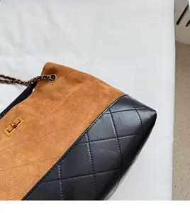 Detail of quilted two-tone shoulder bag with gold twist lock and chain strap