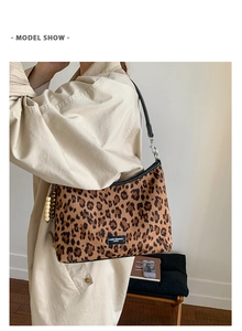 Détail d'un sac léopard avec des lanières en cuir et une breloque en perles de bois