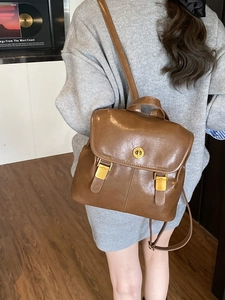 Vintage brown leather backpack for women with flap cover and gold twist lock detail