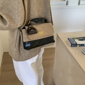 Detail of vintage flap bag showing khaki suede and black quilted leather with gold lock