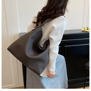 Large dark grey minimalist tote bag styled with a white blazer for work commute