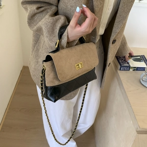 Detailed view of quilted color-block handbag with gold chain strap and metal turn-lock