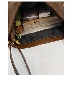 Spacious interior of brown suede bucket bag showing storage for laptop and cosmetics