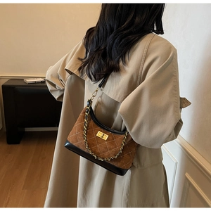 Brown suede hobo bag with diamond stitching and gold clasp shown on a model