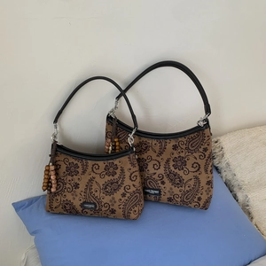 Détail de deux sacs à bandoulière à motif cachemire avec gland en perles de bois