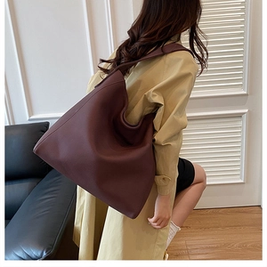 Detail of burgundy large leather tote bag with wide strap for work and daily use