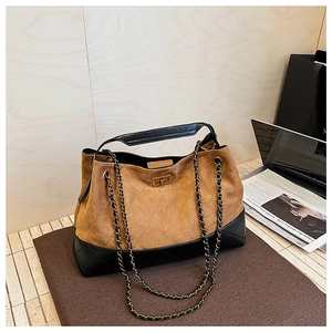 Detail of quilted leather tote featuring suede contrast and golden metal twist lock