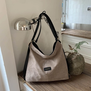 Close-up of matte bucket bag featuring black fashion label and durable metal ring buckles