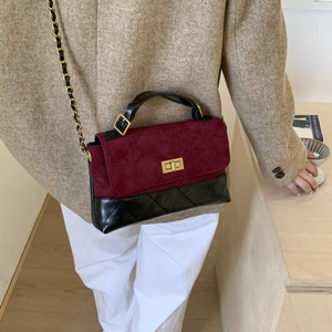 Detail of luxury flap bag with burgundy suede, black diamond quilting and gold lock
