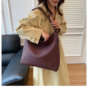 Detail view of the large burgundy tote bag with smooth texture and comfortable shoulder strap