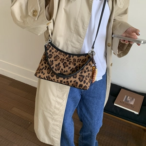 Détail d'un sac à bandoulière léopard avec perles en bois et fine lanière en cuir