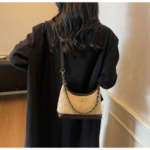 Detail view of khaki suede shoulder bag featuring diamond stitching and gold metal chain