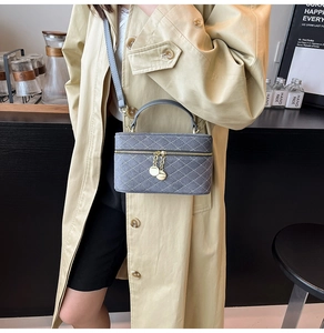 Close-up of quilted grey crossbody bag with gold hardware and elegant chain strap