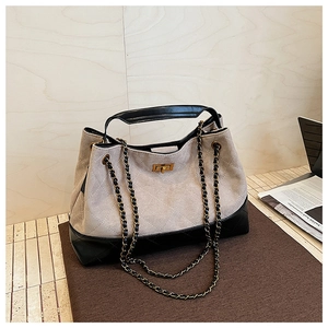 Detail of quilted suede tote bag with leather trim and gold-tone chain strap