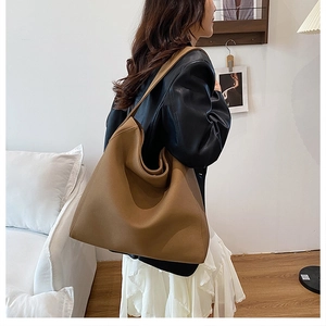 Detail of soft brown leather tote bag showing large capacity and natural texture