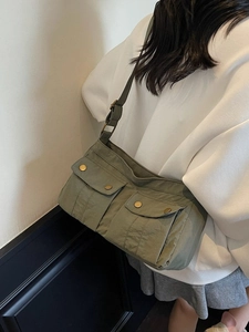 Olive green military-style nylon crossbody bag with large pockets and adjustable strap