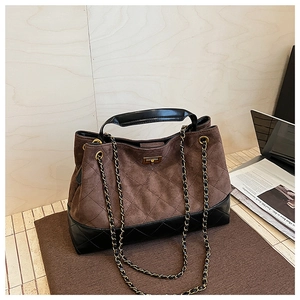 Detail of retro large tote bag with brown suede and black quilted leather textures