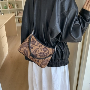 Détail du sac bandoulière à motif paisley avec sangle noire et boucle en métal argenté