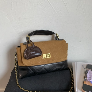 Detailed close-up of retro color-block handbag featuring diamond quilted stitching and gold lock