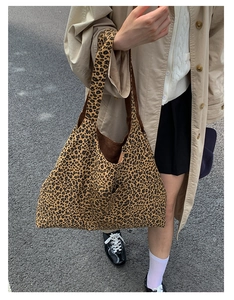 Close-up of a large leopard print tote bag with functional front pocket and brown lining