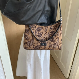 Détail du motif paisley vintage sur le sac à bandoulière avec logo Louie Samani