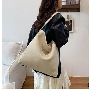Detail view of the spacious beige tote bag worn on shoulder for a minimalist daily commute