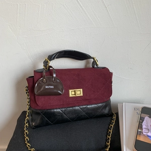 Detailed shot of two-tone quilted leather bag with gold twist lock and brand charm