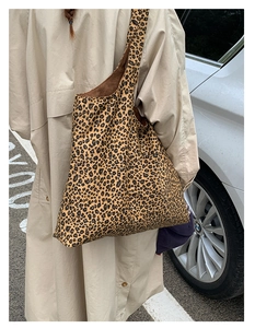 Close-up of leopard print tote bag fabric texture with high-capacity shoulder strap design