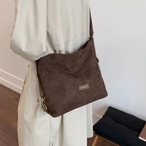 Detail of the brown matte suede hobo bag featuring adjustable golden strap buckle