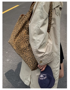 Fashionable leopard print tote bag shown on shoulder of a model in a beige trench coat