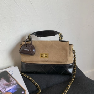 Detail of color-block quilted bag with gold twist lock and brand logo pendant