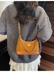 Brown suede hobo bag with white diamond stitching and gold chain strap shown on model