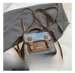 Detail showing vintage denim and brown leather patchwork backpack with gold metal buckles