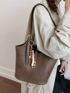 Retro brown matte leather bucket bag with vintage gold hardware and beaded charm detail