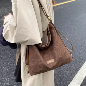 Detail of dark brown suede bucket bag showing large capacity and soft texture