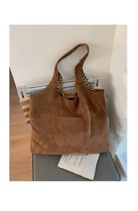 Detail view of large brown suede tote bag with leopard print lining and front pocket