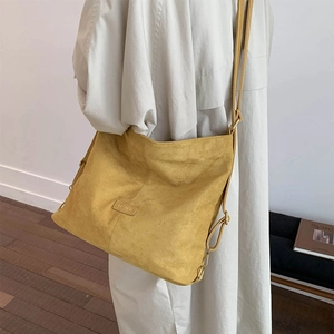Detail of ginger matte bucket bag with adjustable strap and embossed fashion label