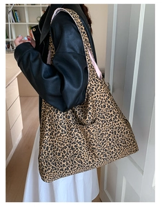 Close-up of leopard print tote bag featuring a practical front pocket and pink inner lining