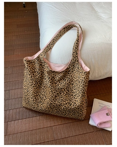 Detail view of large leopard print tote bag with contrasting pink lining and wide straps